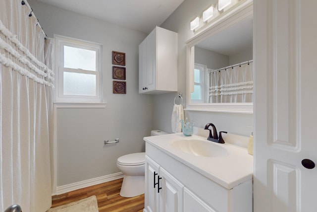 full bath with baseboards, wood finished floors, toilet, and vanity