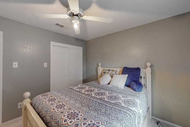 carpeted bedroom with baseboards, a ceiling fan, a closet, and visible vents