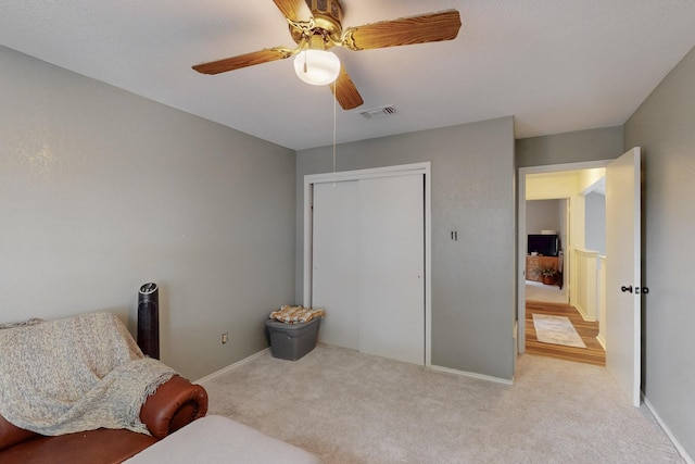 living area featuring carpet floors, a ceiling fan, baseboards, and visible vents