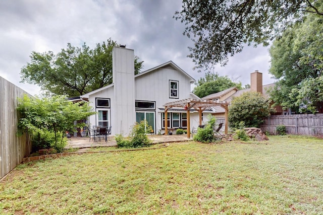 rear view of property with a pergola, a fenced backyard, a chimney, a lawn, and a patio