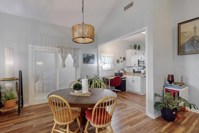 dining area with baseboards, visible vents, and light wood-style flooring