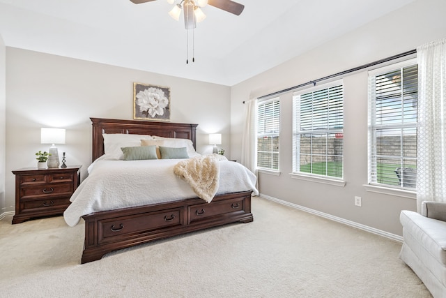 bedroom with a ceiling fan, baseboards, light colored carpet, and multiple windows