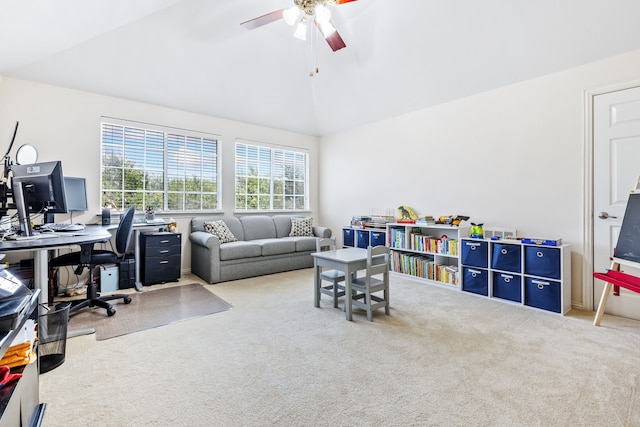 carpeted home office with ceiling fan and vaulted ceiling
