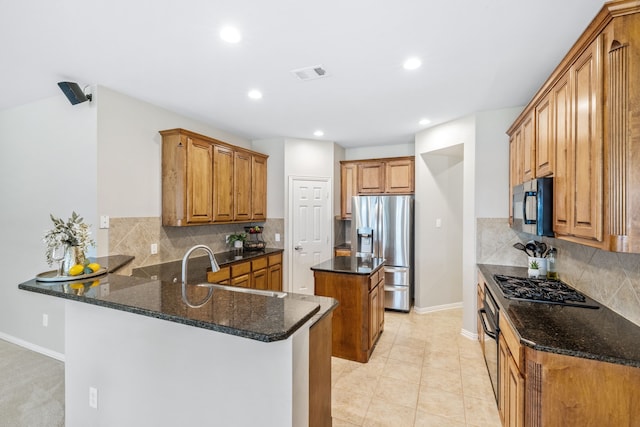 kitchen featuring visible vents, a sink, baseboards, black appliances, and a peninsula