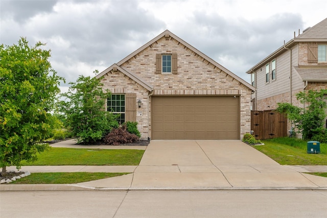 view of front of home with a front lawn, brick siding, a garage, a gate, and concrete driveway