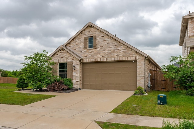 view of front of property featuring concrete driveway, brick siding, fence, and a front yard