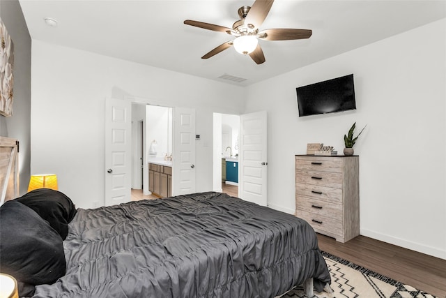 bedroom with visible vents, light wood-type flooring, a sink, baseboards, and ensuite bathroom
