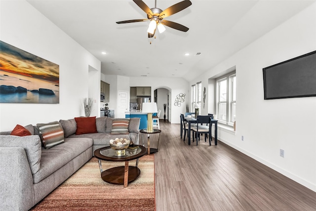 living room featuring arched walkways, a ceiling fan, recessed lighting, and dark wood-type flooring