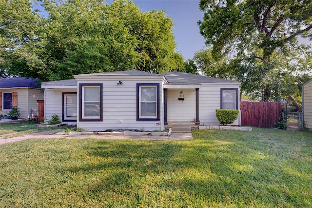 ranch-style house with fence and a front lawn
