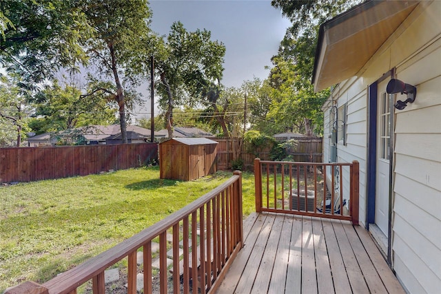 wooden deck with a fenced backyard, an outbuilding, a yard, and a storage shed