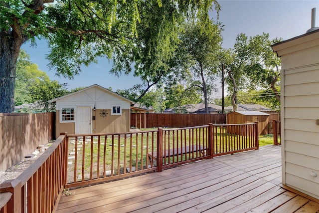 wooden deck featuring an outdoor structure, a fenced backyard, and a shed