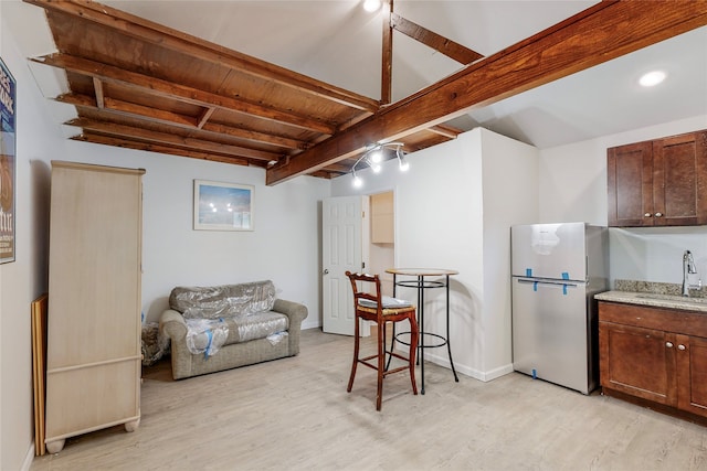 interior space with beamed ceiling, wooden ceiling, baseboards, and light wood finished floors