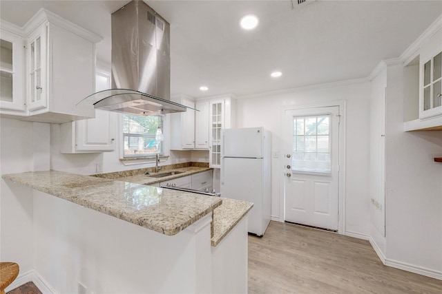 kitchen featuring plenty of natural light, freestanding refrigerator, a sink, and island range hood