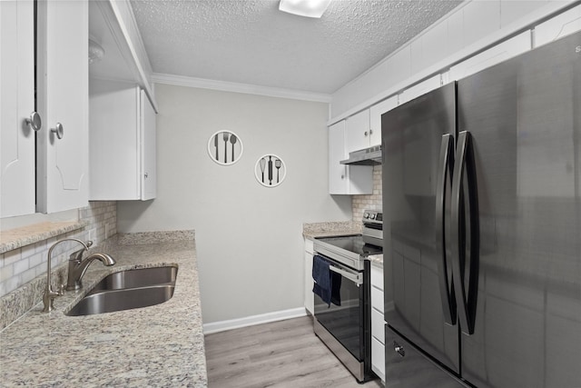 kitchen featuring tasteful backsplash, a sink, freestanding refrigerator, stainless steel electric stove, and under cabinet range hood