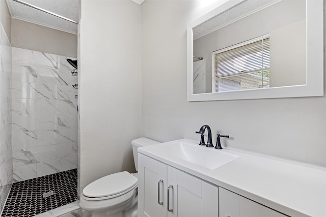 bathroom with vanity, toilet, tiled shower, and marble finish floor