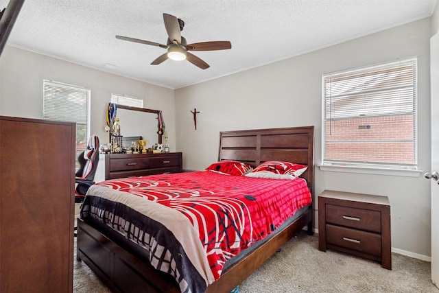 carpeted bedroom featuring baseboards, a ceiling fan, a textured ceiling, and crown molding