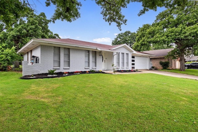 ranch-style house featuring brick siding, an attached garage, driveway, and a front yard