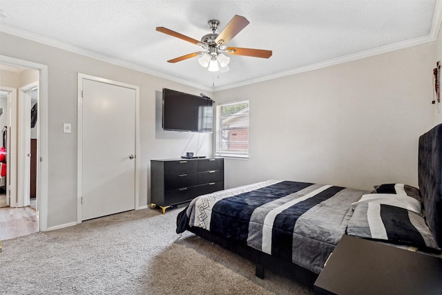 carpeted bedroom featuring crown molding, baseboards, and ceiling fan