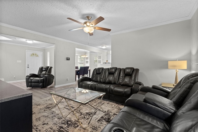 living room with a textured ceiling, crown molding, wood finished floors, baseboards, and ceiling fan with notable chandelier