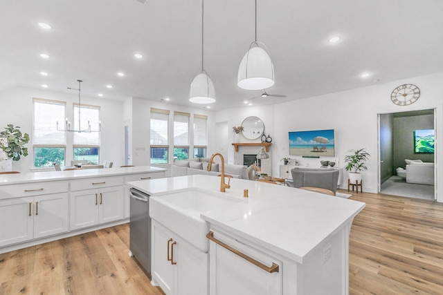 kitchen with a fireplace, light wood-style floors, open floor plan, recessed lighting, and a sink