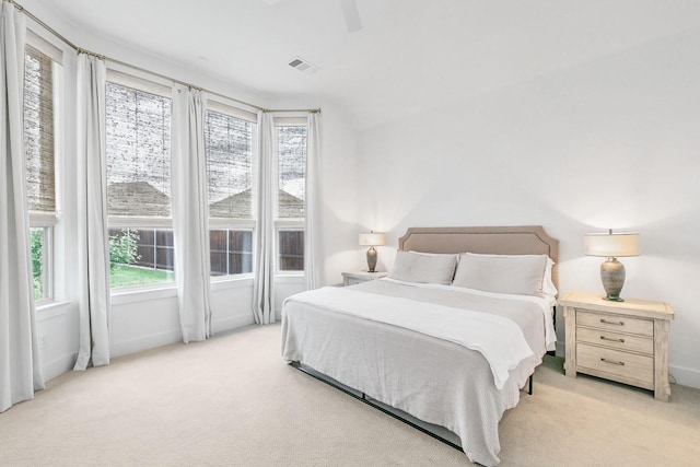 carpeted bedroom featuring baseboards, visible vents, and multiple windows
