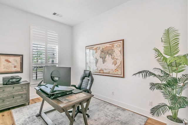 office area featuring visible vents, light wood-style floors, and baseboards