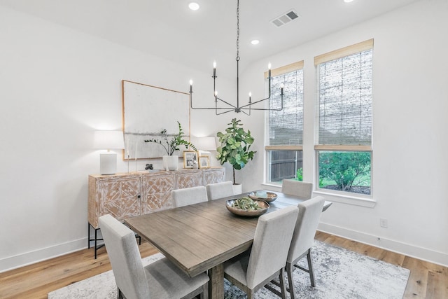 dining room featuring baseboards, an inviting chandelier, wood finished floors, and visible vents