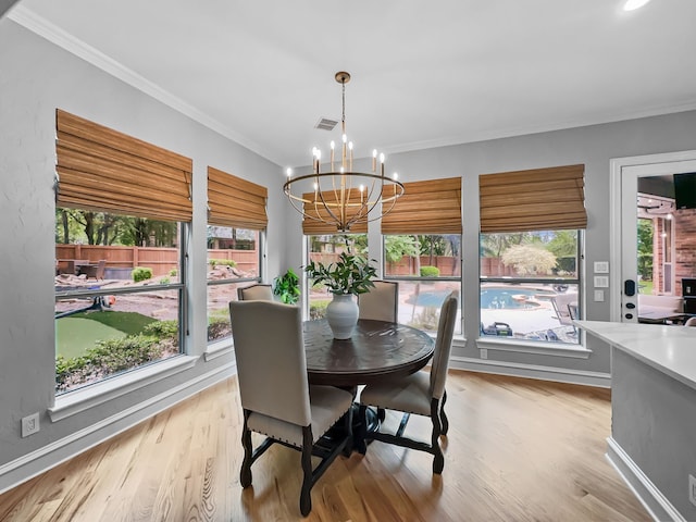 dining area featuring crown molding, plenty of natural light, and an inviting chandelier
