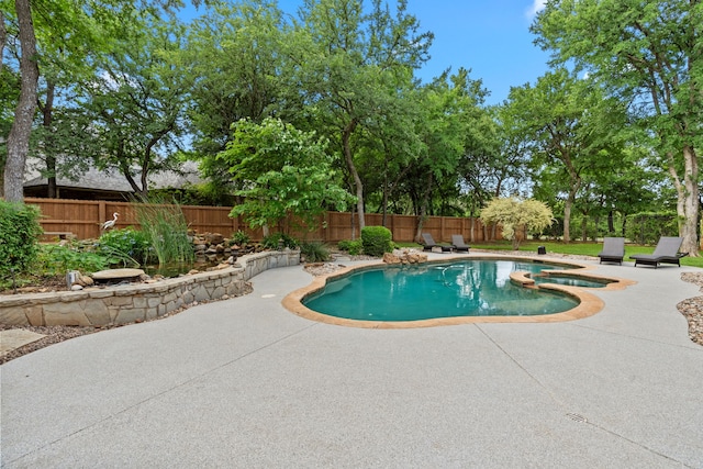 view of pool featuring a fenced backyard, a patio area, and a pool with connected hot tub
