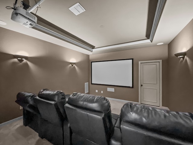 home theater room featuring visible vents, a raised ceiling, baseboards, and light carpet