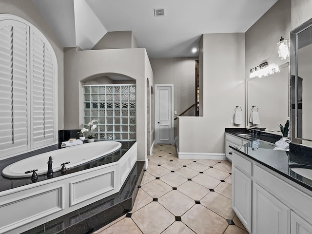 bathroom featuring vanity, baseboards, and a bath