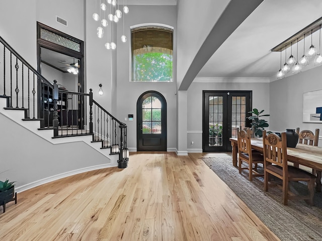foyer with french doors, stairs, wood finished floors, and visible vents