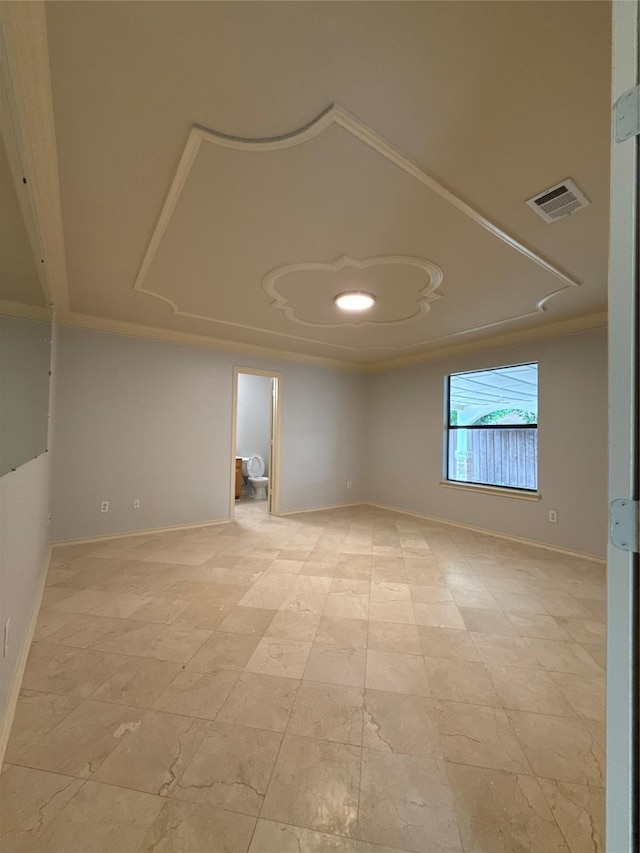 spare room featuring crown molding, baseboards, and visible vents
