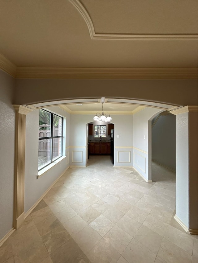 unfurnished dining area featuring plenty of natural light, arched walkways, and a decorative wall