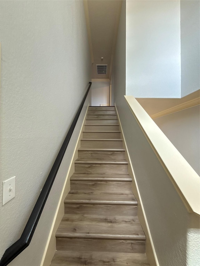 staircase featuring wood finished floors and visible vents