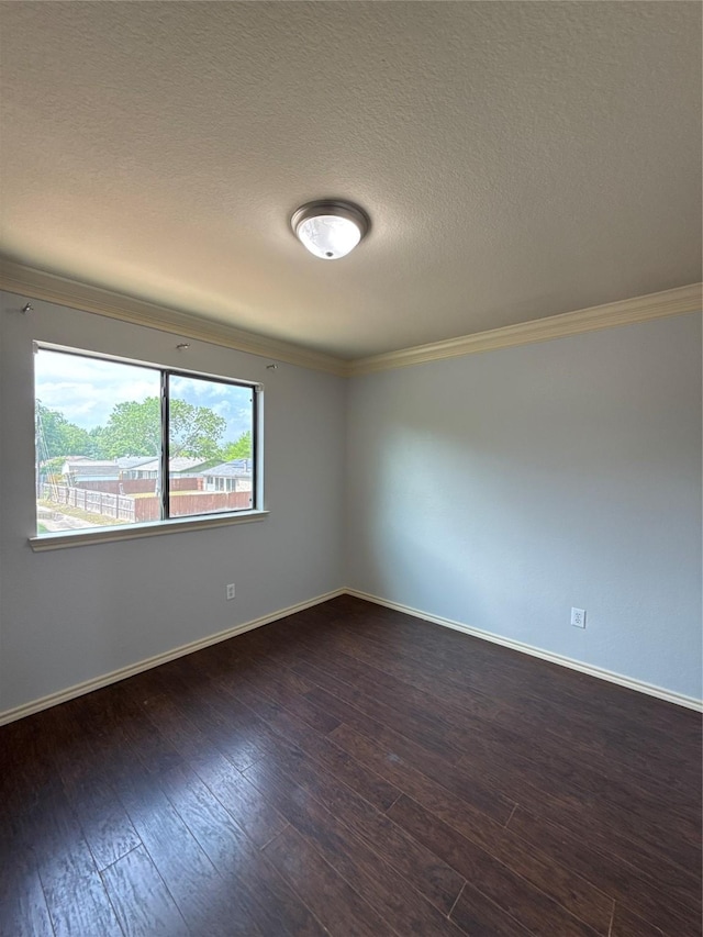 empty room with crown molding, baseboards, a textured ceiling, and dark wood-type flooring