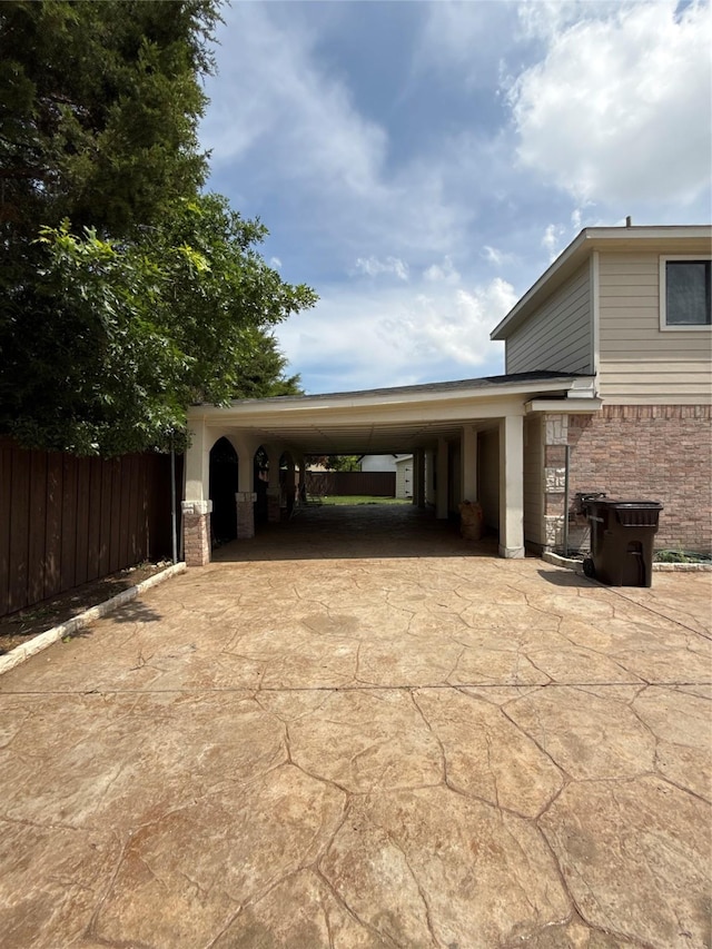 view of car parking with fence and concrete driveway