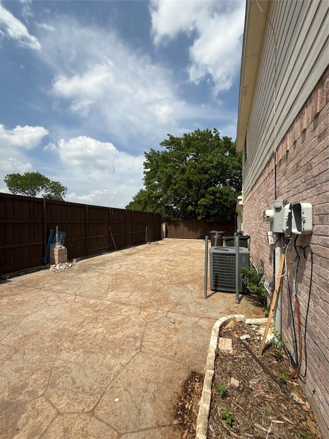 view of yard with central AC and fence