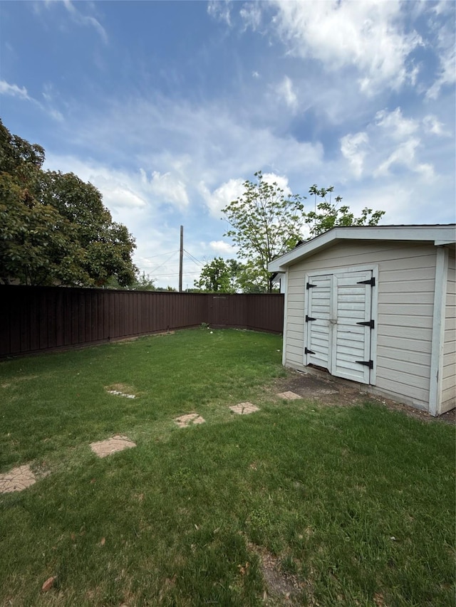 view of yard with fence, a storage unit, and an outdoor structure
