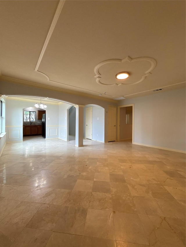 unfurnished room featuring visible vents, ornamental molding, baseboards, arched walkways, and a notable chandelier