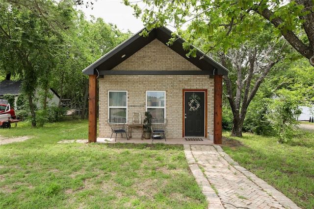 view of front of house featuring brick siding and a front yard