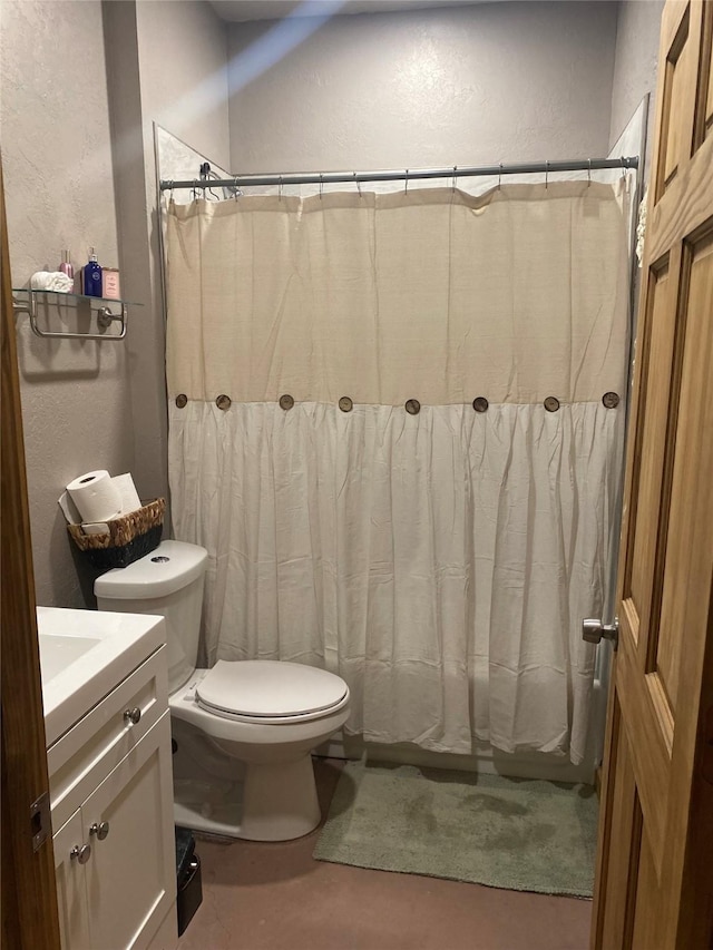 full bath featuring vanity, a textured wall, shower / bath combo with shower curtain, and toilet