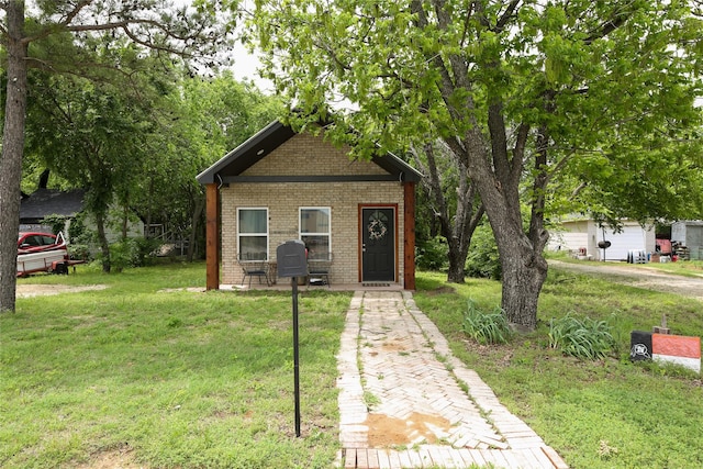bungalow-style home with a front yard and brick siding