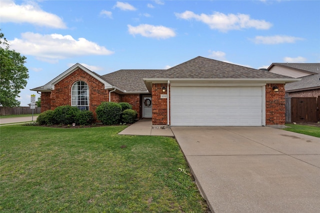 single story home featuring a garage, fence, a front yard, brick siding, and concrete driveway