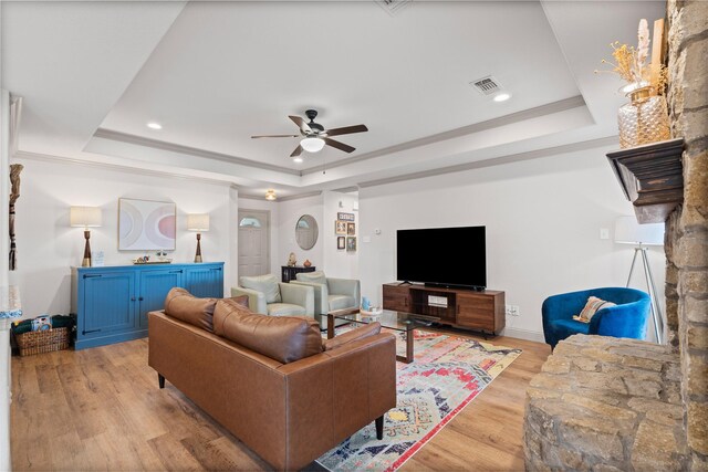 living area with ceiling fan, visible vents, a raised ceiling, recessed lighting, and light wood-style flooring