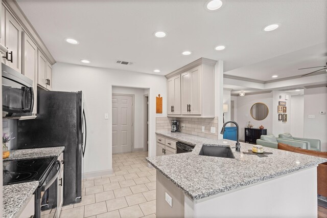 kitchen with electric range, a sink, open floor plan, stainless steel microwave, and visible vents
