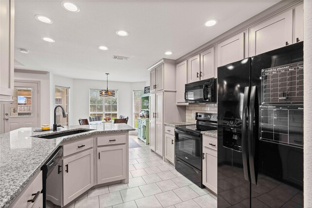 kitchen with electric range, a sink, open floor plan, stainless steel microwave, and visible vents