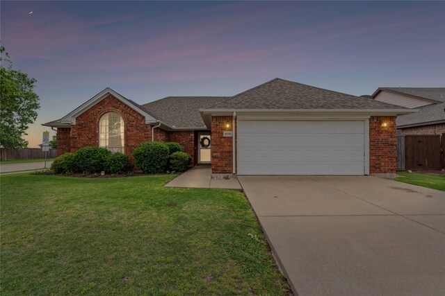 single story home with a garage, a front lawn, fence, brick siding, and a shingled roof