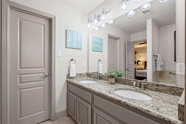 bathroom with double vanity, tile patterned floors, a sink, and a jetted tub