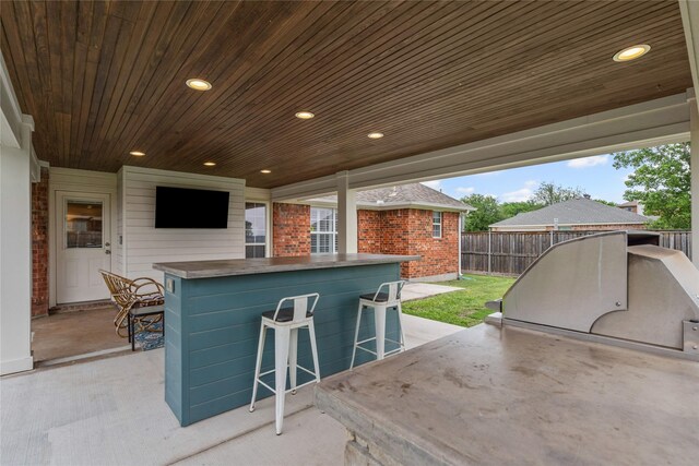 view of patio featuring fence and outdoor dry bar
